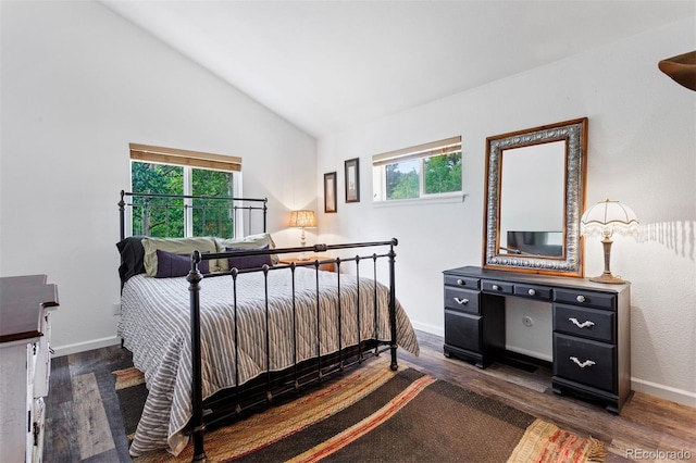 bedroom featuring multiple windows, dark hardwood / wood-style flooring, and vaulted ceiling