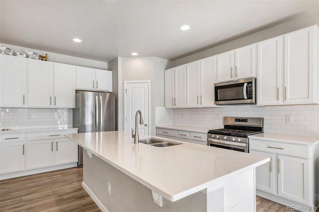 kitchen with light hardwood / wood-style flooring, white cabinets, appliances with stainless steel finishes, and sink