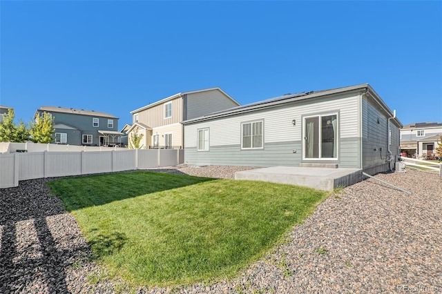 rear view of house with a patio and a yard