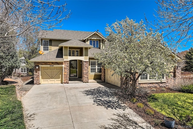 traditional home featuring an attached garage, roof with shingles, driveway, and stone siding