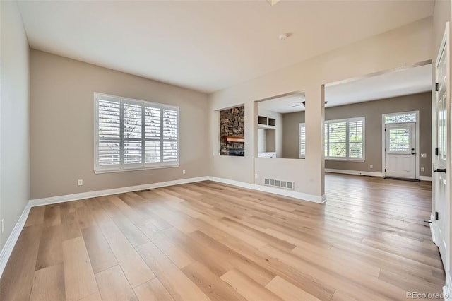 unfurnished living room featuring ceiling fan, visible vents, baseboards, and light wood-style floors