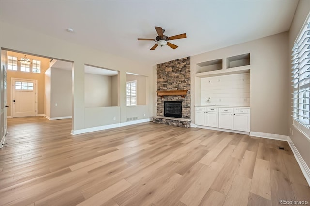 unfurnished living room featuring a healthy amount of sunlight, a ceiling fan, and visible vents