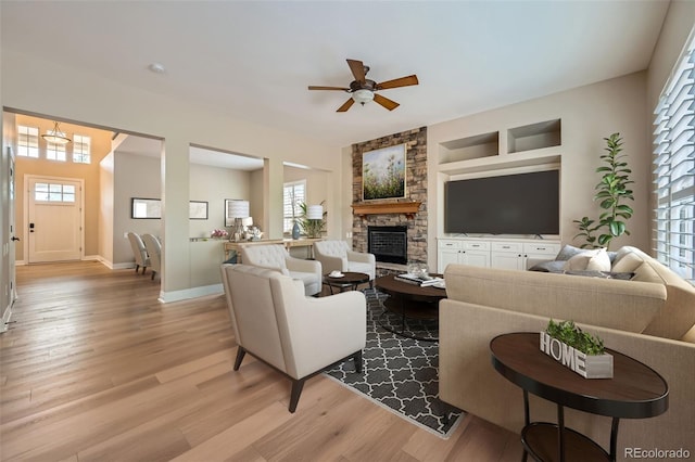 living room featuring light wood-style floors, baseboards, and a wealth of natural light