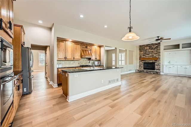 kitchen with ceiling fan, visible vents, dark countertops, light wood-type flooring, and stainless steel appliances
