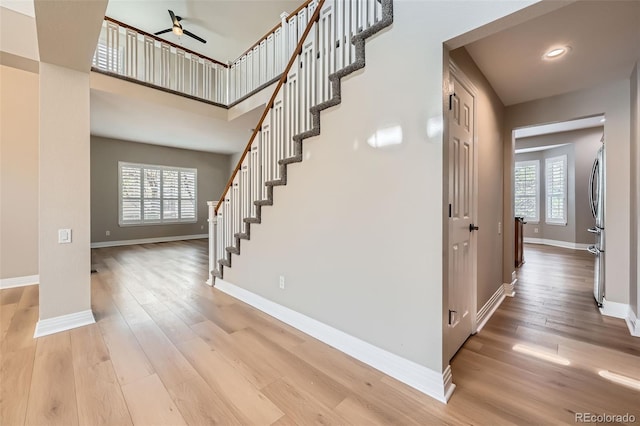 interior space with baseboards, ceiling fan, and wood finished floors