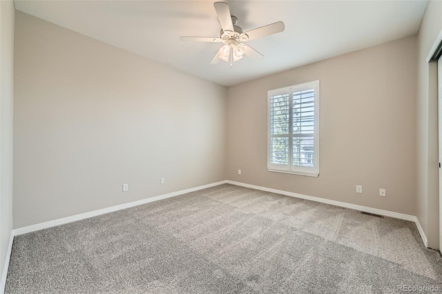 spare room with baseboards, carpet flooring, and ceiling fan