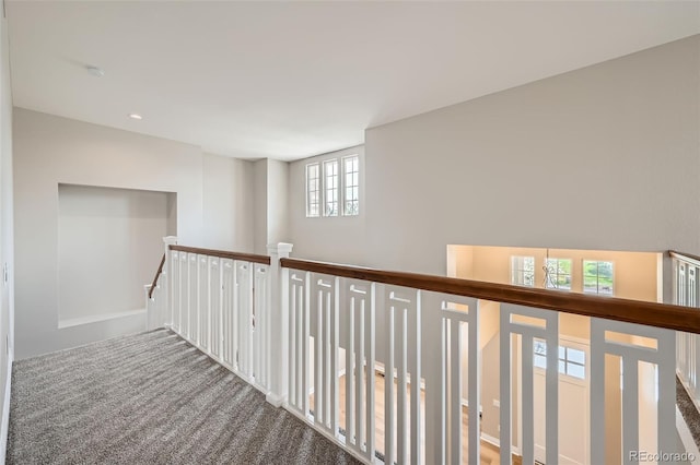 hallway featuring carpet flooring and an upstairs landing