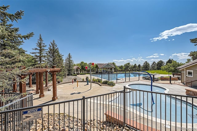 pool with a patio and a hot tub