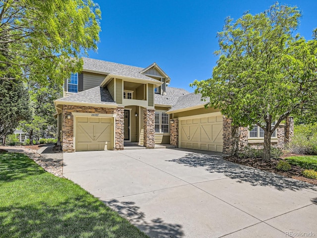 24487 E Frost Dr, Aurora, CO 80016 - view of front of house with stone siding, concrete driveway, an attached garage, and roof with shingles