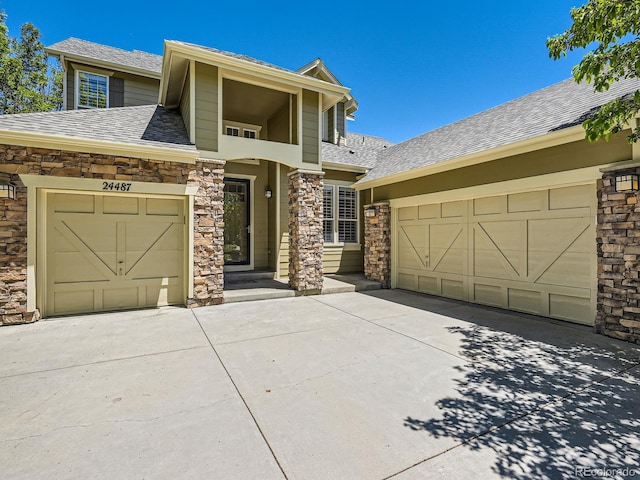 24487 E Frost Dr, Aurora, CO 80016 - view of front of home with concrete driveway, stone siding, an attached garage, and a shingled roof