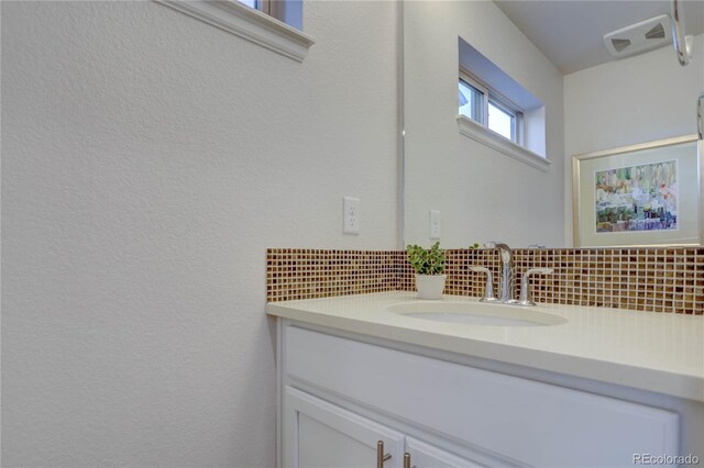 bathroom with vanity and backsplash