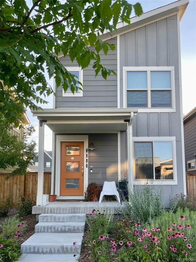 5863 N Boston St, Denver, CO 80238 - view of exterior entry with board and batten siding, fence, and covered porch