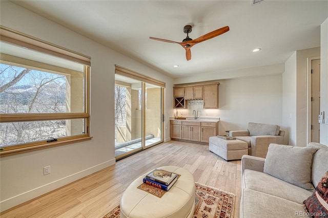 living room featuring recessed lighting, light wood-style floors, baseboards, and ceiling fan