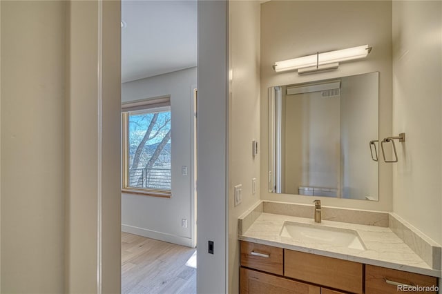 bathroom featuring vanity, baseboards, and wood finished floors