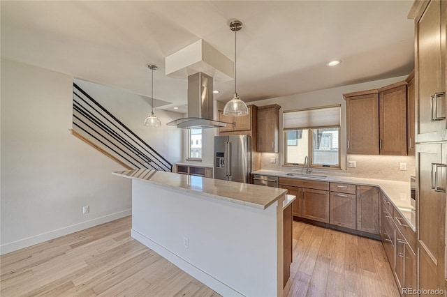 kitchen featuring light wood-style flooring, a sink, a kitchen island, appliances with stainless steel finishes, and island range hood