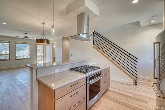 kitchen with light stone countertops, light wood-style flooring, recessed lighting, stainless steel appliances, and island range hood