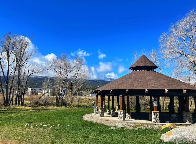 view of property's community featuring a gazebo, a lawn, and a mountain view