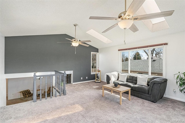 living room featuring baseboards, lofted ceiling with skylight, carpet, and a ceiling fan