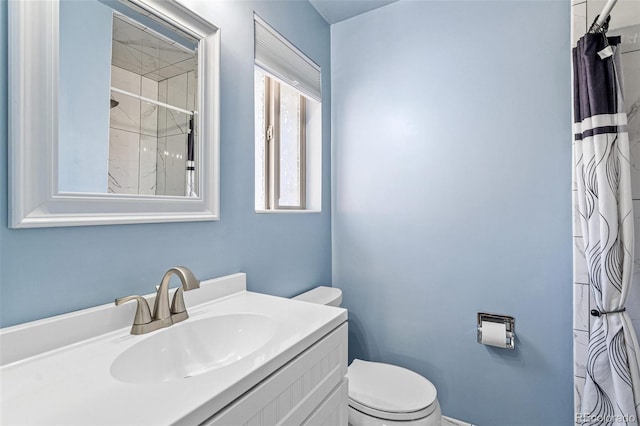 bathroom featuring curtained shower, toilet, and vanity