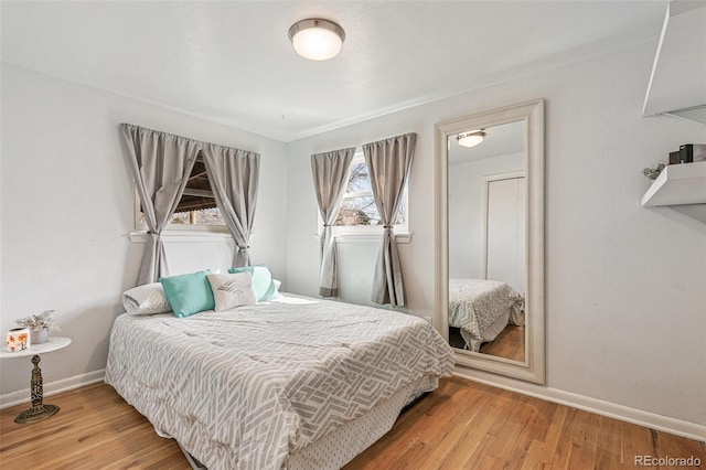 bedroom with baseboards and wood finished floors