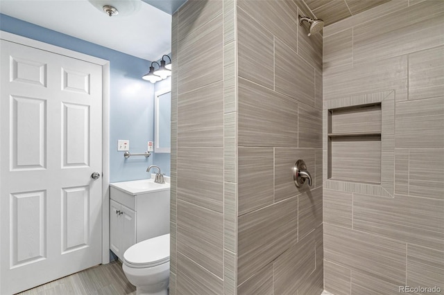 full bath with vanity, toilet, and tiled shower