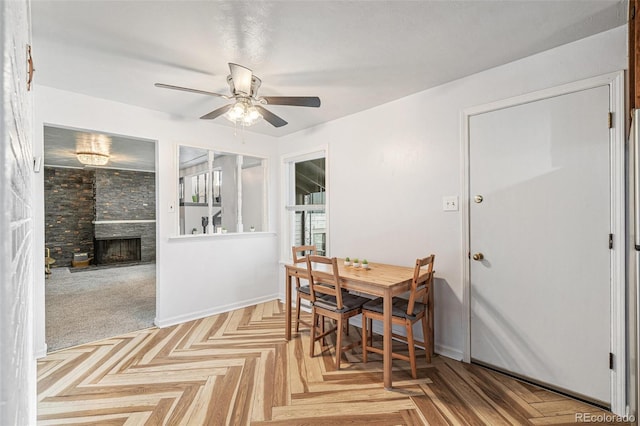 6190 Garrison St, Arvada, CO 80004 - dining area featuring a ceiling fan, a fireplace, and baseboards