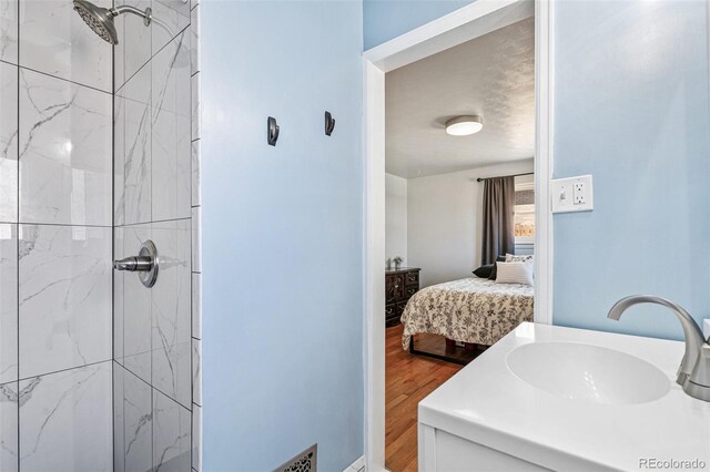 6190 Garrison St, Arvada, CO 80004 - full bathroom with connected bathroom, a tile shower, wood finished floors, and vanity