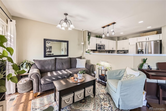 1974 E 102nd Cir, Thornton, CO 80229 - living area featuring a chandelier, wood finished floors, and recessed lighting