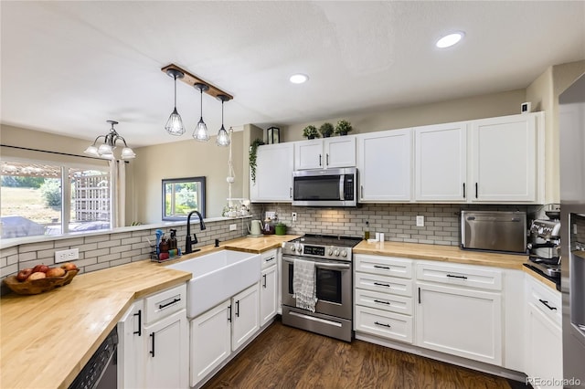 1974 E 102nd Cir, Thornton, CO 80229 - kitchen with butcher block countertops, appliances with stainless steel finishes, white cabinetry, tasteful backsplash, and recessed lighting