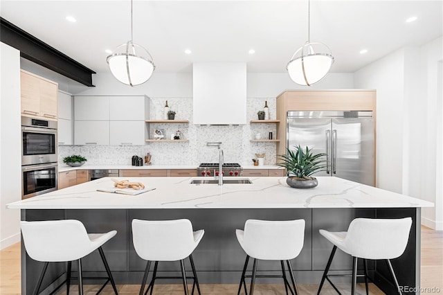 kitchen featuring stainless steel appliances, white cabinetry, and a kitchen island with sink