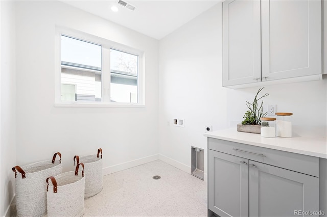 clothes washing area with hookup for an electric dryer, cabinets, and washer hookup