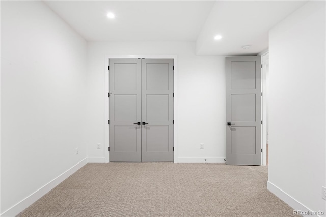 unfurnished bedroom featuring light carpet and a closet