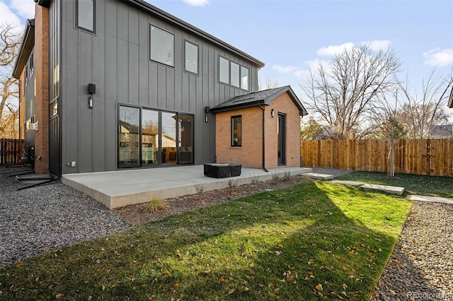 back of house with a yard and a patio