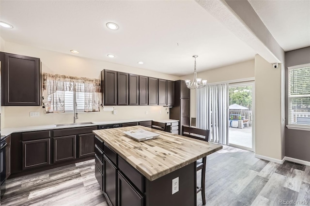 334 Octillo St, Brighton, CO 80601 - kitchen with a sink, wood counters, a chandelier, a breakfast bar, and light wood-style floors
