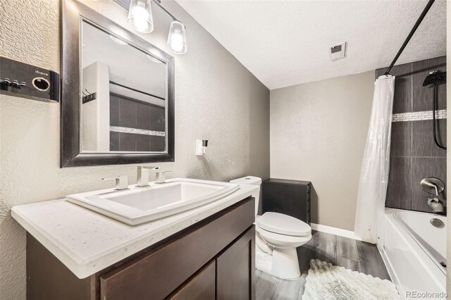 334 Octillo St, Brighton, CO 80601 - full bathroom featuring wood finished floors, a textured wall, vanity, toilet, and shower / bath combo with shower curtain