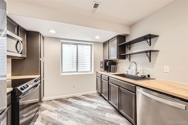 334 Octillo St, Brighton, CO 80601 - kitchen featuring stainless steel appliances, a sink, open shelves, light wood-type flooring, and dark brown cabinetry