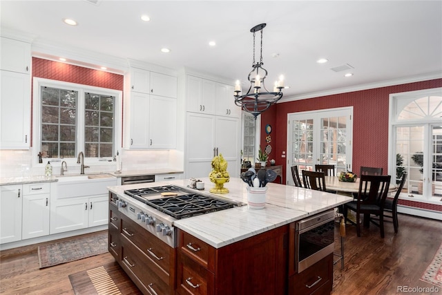 4 Cherry Hills Farm Dr, Cherry Hills Village, CO 80113 - kitchen with stainless steel gas stovetop, built in microwave, a chandelier, ornamental molding, and a sink