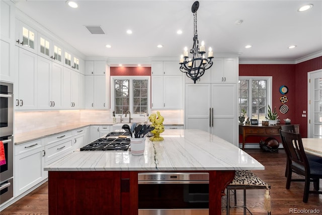 4 Cherry Hills Farm Dr, Cherry Hills Village, CO 80113 - kitchen with a chandelier, a center island, crown molding, stainless steel gas stovetop, and dark wood-style flooring