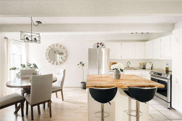 1365 Columbine St Unit 204, Denver, CO 80206 - kitchen with appliances with stainless steel finishes, a chandelier, a sink, a kitchen island, and white cabinets