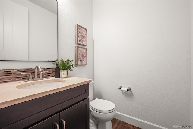 bathroom featuring decorative backsplash, vanity, toilet, and hardwood / wood-style floors