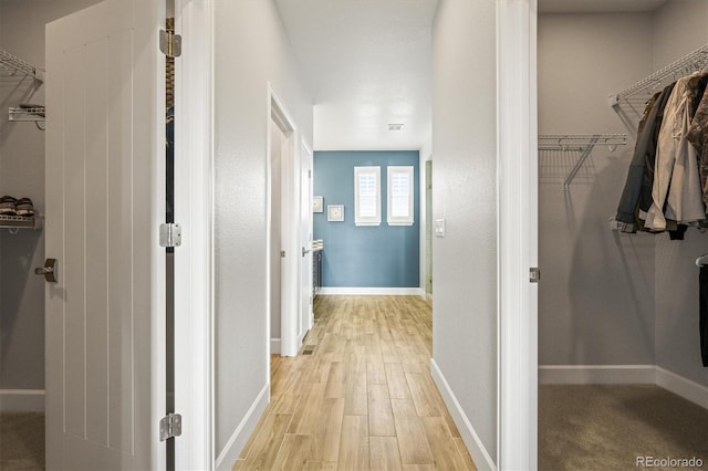 hallway with light hardwood / wood-style floors