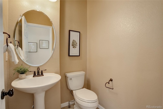 half bath with toilet and baseboards