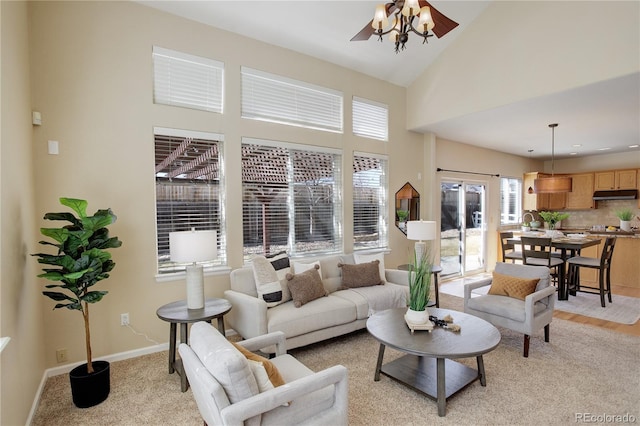 living area featuring baseboards, high vaulted ceiling, and ceiling fan