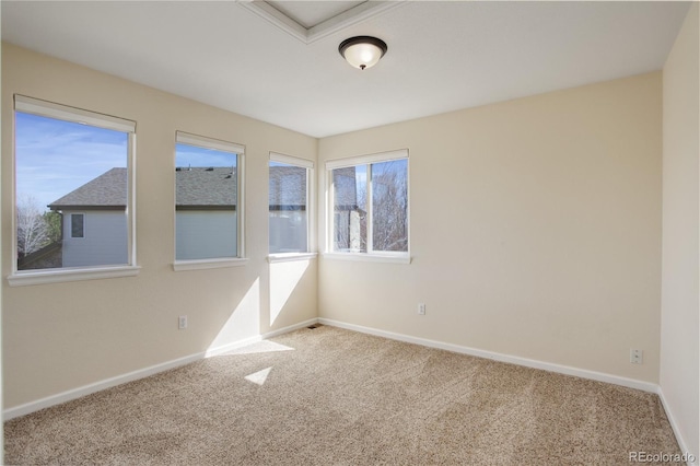 empty room featuring carpet and baseboards