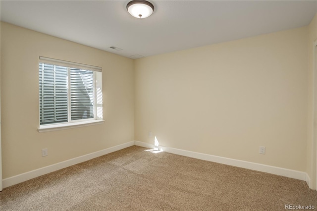 spare room featuring visible vents, carpet, and baseboards