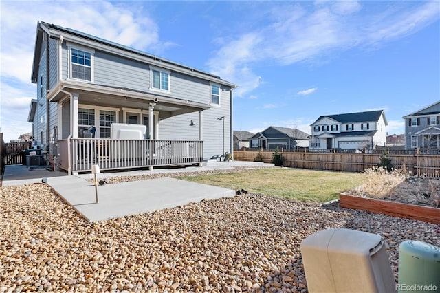 back of house featuring a patio, a wooden deck, and a lawn