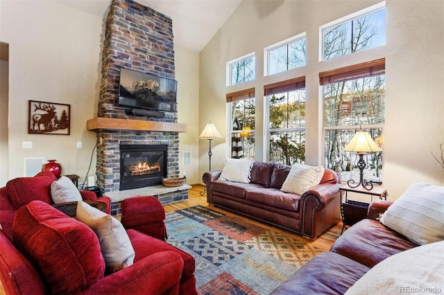 living room featuring a fireplace, high vaulted ceiling, and wood finished floors