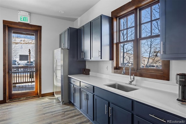 kitchen with a wealth of natural light, light countertops, a sink, and light wood finished floors