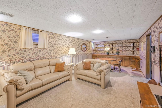 living area featuring wallpapered walls and visible vents