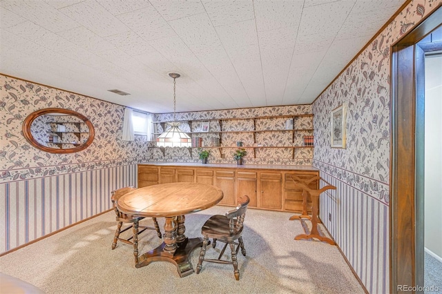 dining room with light carpet, visible vents, and wallpapered walls